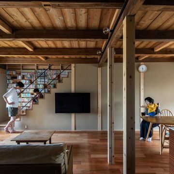 たくさんの蔵書のため階段周りに本棚を造作。左手の階段上は文庫・新書・コミックなど奥行きの浅い開架ライブラリ。右手の階段下は単行本・雑誌など奥行きの深い書籍を納める書庫。