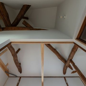 2階天井見上げ。寄棟の複雑な架構。壁・天井を白く塗った明るい空間。