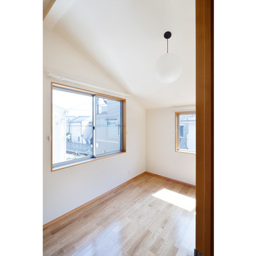 傾斜天井に2面に窓のある寝室