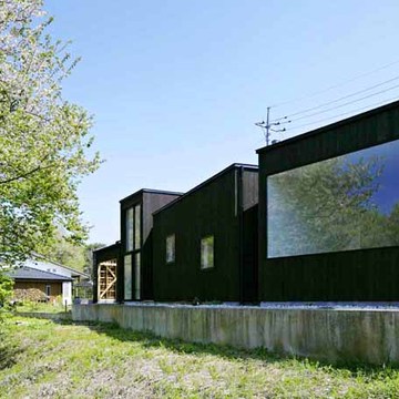 多様な箱が角度を変えながら雑木林に寄り添う