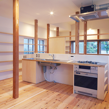 古い柱の残る一室空間の中央部に作付けたキッチン