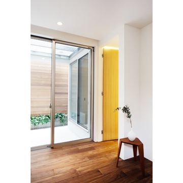 フローリングと中庭の木壁がホッとする1階寝室