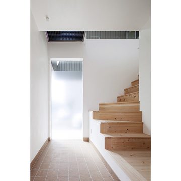 明るいエントランスから緩やかに2階に誘導する階段