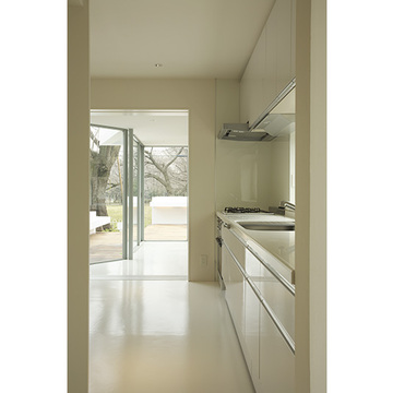 全面ガラスからの光に溢れる白いキッチン