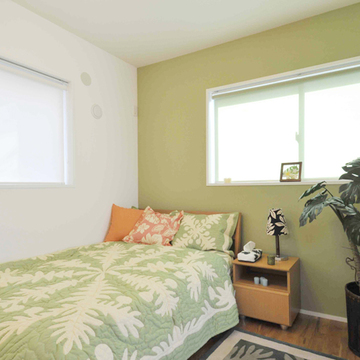 １面をグリーンの壁紙にした落ち着きのある主寝室