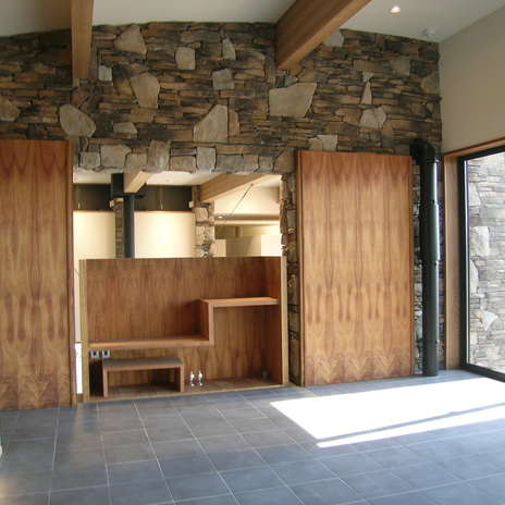 木目が美しい扉を開けると吹き抜けのリビングに繋がる