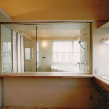 バスルームのガラス張りから明るい光が差し込む洗面スペース