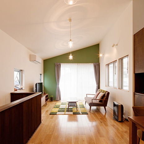 深緑の壁と勾配天井で広く感じるLDK