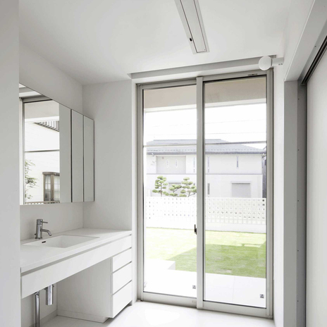 中庭を見ながら身支度ができる、明るく開放的な白一色の洗面脱衣室