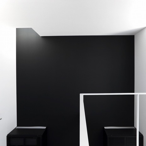 黒と白の壁に当たる光が、壁に立体的な表情を与える吹抜け