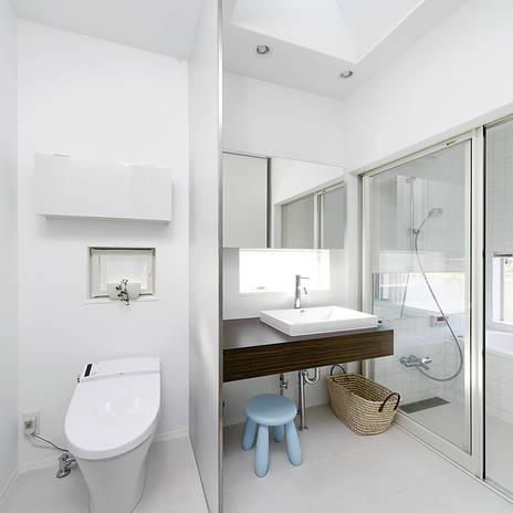 川の流れに癒やされながら入浴できる、真っ白にまとめられた爽やかな洗面・浴室