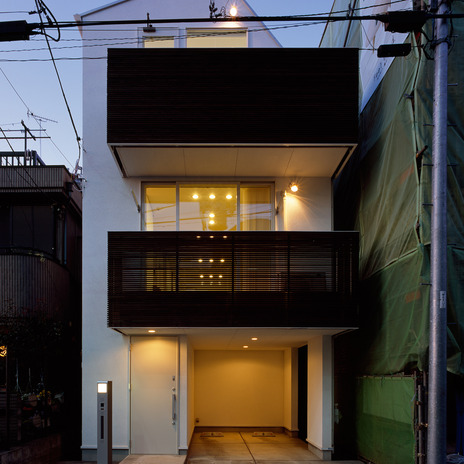ルーバーの隙間から見えるぼんやりと灯される光が魅力的な夜の外観