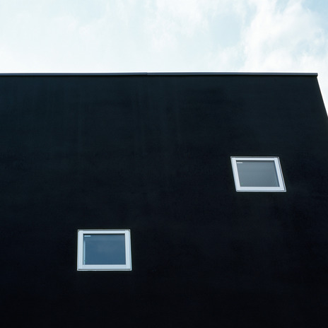 真っ黒な壁面に、小さなスクエア窓がかわいらしく配置する