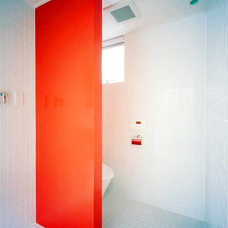 インパクトのある朱い壁が特徴の水まわり