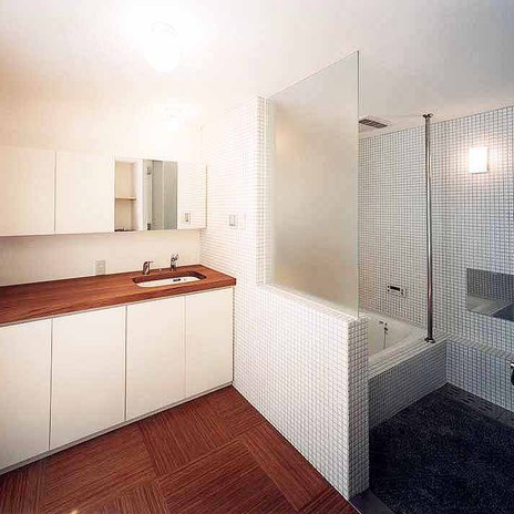 白いタイルで浴室を包み込んだ、清潔感ある広い浴室