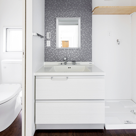 白い空間にグレーのタイルがモダンな雰囲気を醸し出す洗面・トイレ