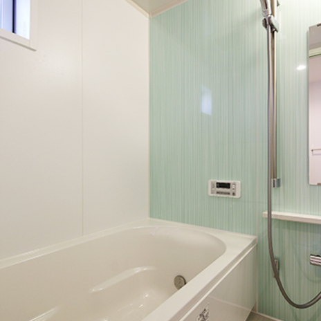 パステルグリーンの壁が爽やかなバスルーム