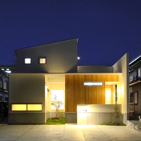 シンプルな白い壁と温かみのある木の質感が浮かび上がる夜景