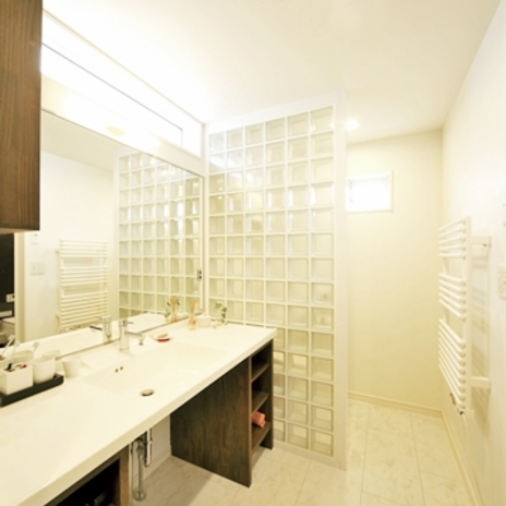 大きな鏡とガラスブロックでゆったりとした印象に