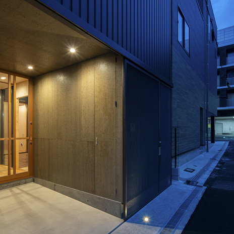 吊戸左手のドアは壁面と同仕上で設えた小さな収納。バイク用品などを整理。