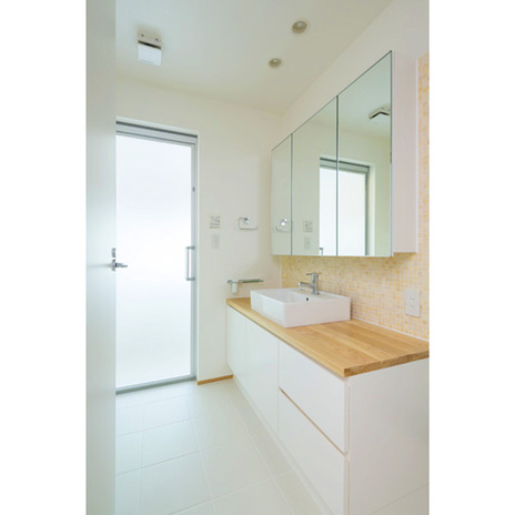 洗面室。浴室のサッシからの日差しが明るい。