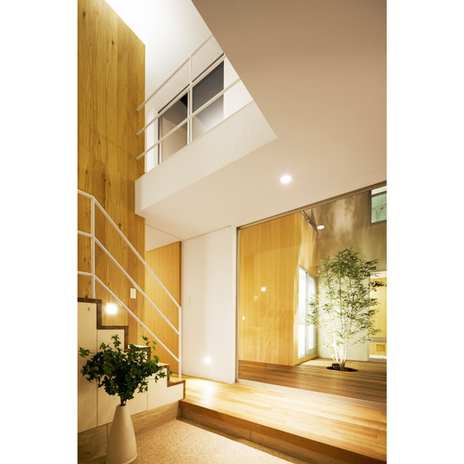 中庭の灯りと間接照明が温かく家主を迎える玄関スペース