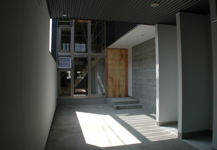 モノトーンにナチュラルな扉が柔らかさを出しているエントランス