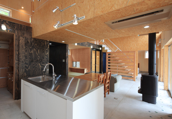 壁の木目と床のたたきのコントラストが印象的な土間リビング