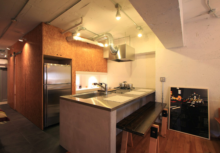 床材のフローリングとタイルにキッチン裏のブラウンの壁が落ち着いた雰囲気を作り出す