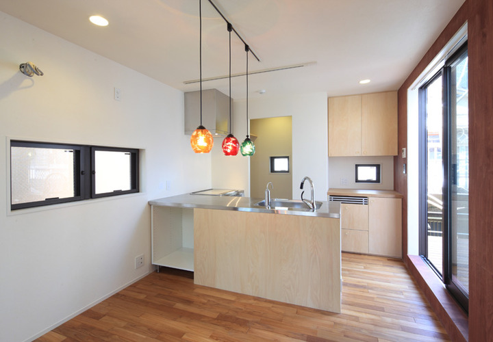 照明にアクセントを付け、シンプルにまとまったL字型キッチン
