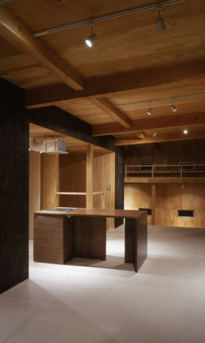 ナチュラルな木目の空間にダークトーンの壁とテーブルがアクセント