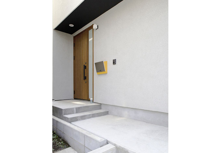 白壁に際立つ玄関ドアとポスト