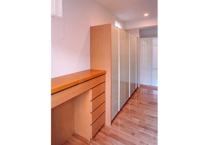 キッチン裏に並ぶ淡いグリーンの収納棚