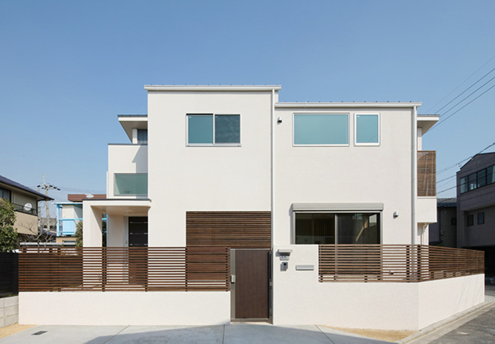 シンプルな白壁に木柵が映える外観
