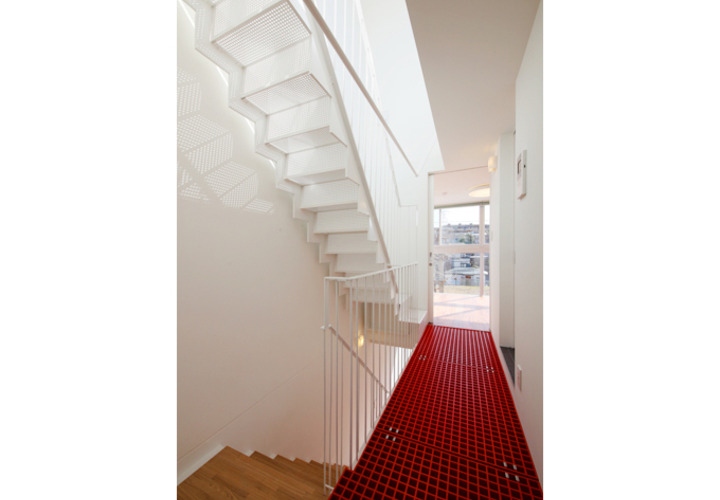 階段上の廊下にはビビッドな赤でアクセントを