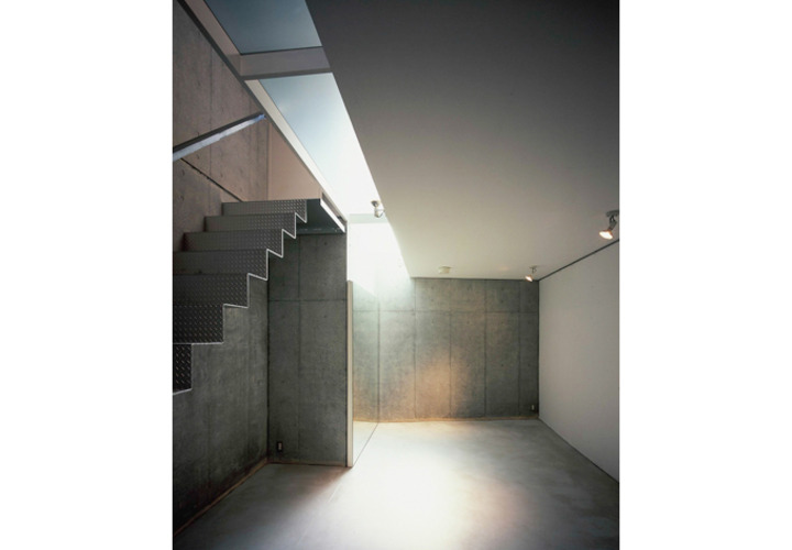 トップライトの光が降り注ぐコンクリート壁のリビング