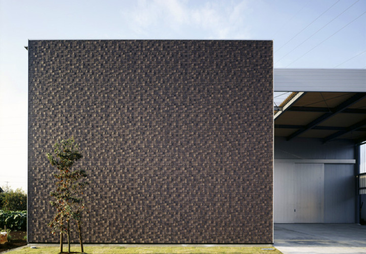 木と外壁のコントラストがアート作品のような外観