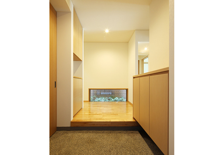 地窓からのぞく緑が迎える玄関ホール