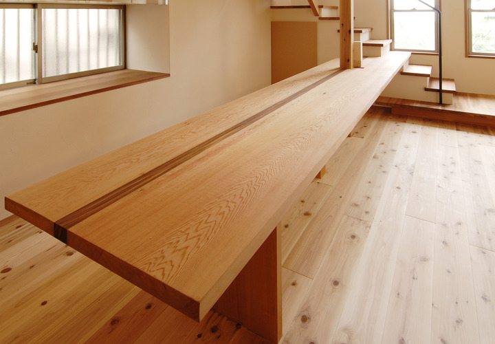 階段から続く造り付け一枚板のユニークなダイニングテーブル