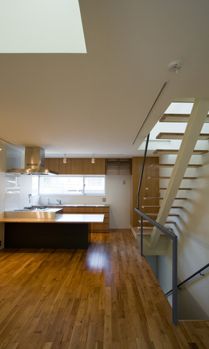 白い空間に床とキッチンの木目が映えるリビングダイニングキッチン