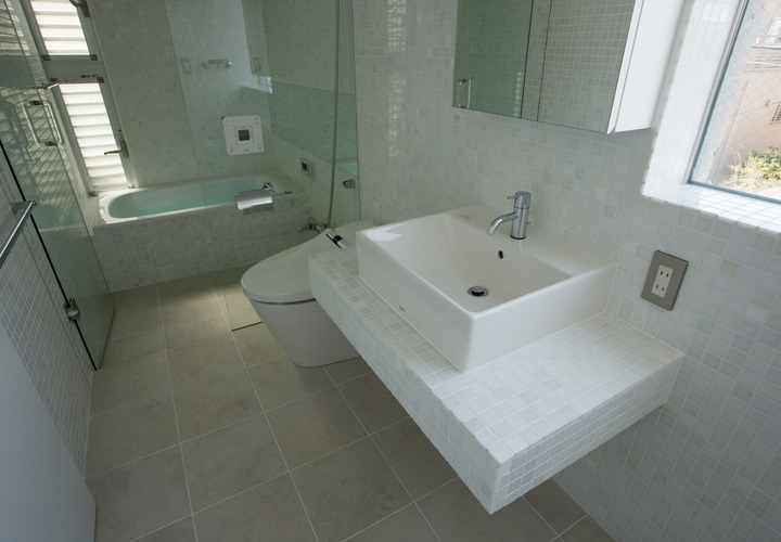 ニュアンスのあるタイル張りが白い空間にアクセントとなり落ち着いた雰囲気のバスルーム