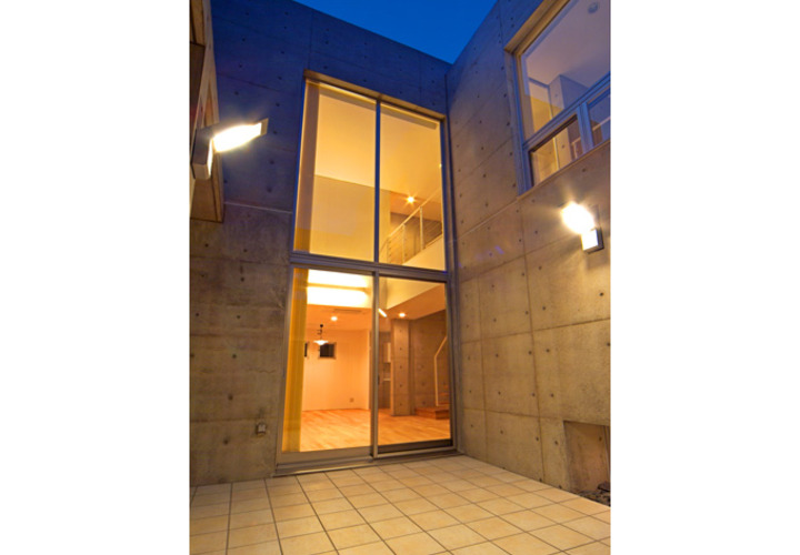 中庭から吹き抜けのリビングを眺める