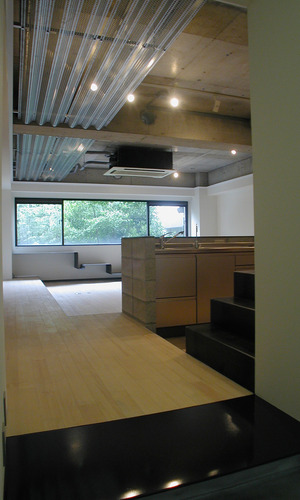 御影石の式台のエントランスから窓の借景の緑が気持ち良いリビングダイニングキッチン