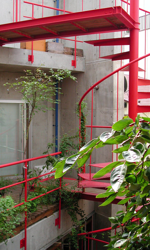 無機質なコンクリート打ち放しに真っ赤な階段がアクセントに