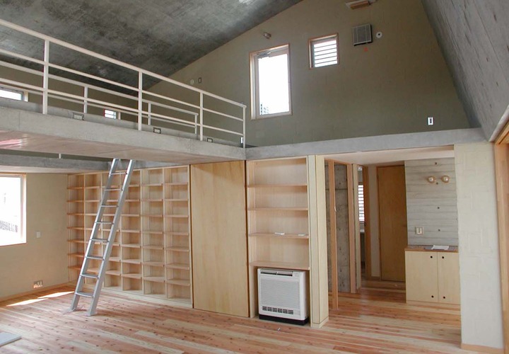 無機質なコンクリート打ち放しに杉フローリングと中霧島壁がナチュラルな印象に