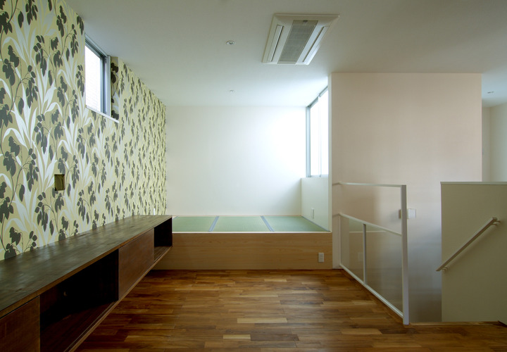 壁の一面をアクセントにし、フリースペースとしてタタミを置いたリビング