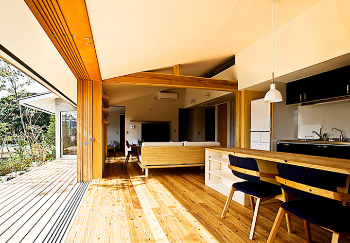 木製全開サッシで雑木林のような庭と繋がる広間