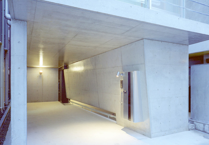 天井と壁の少し傾いた駐車場を兼ねたアプローチ