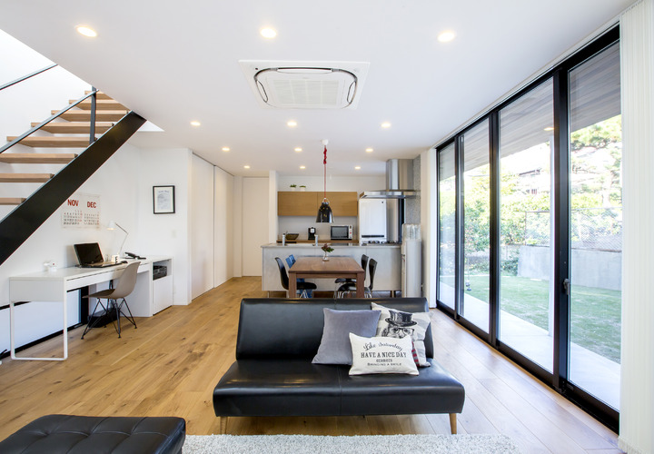 幅広オークフローリングを使用したリビングは中庭とのつながりでより広く見せている