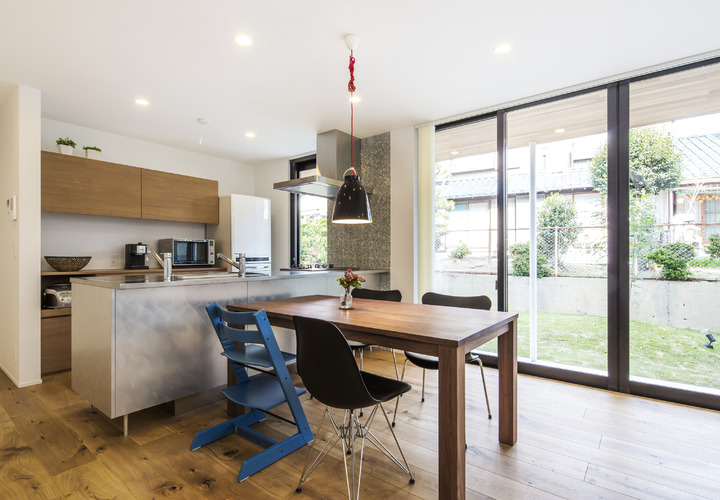 ペニンシュラタイプのキッチンと庭を楽しめるダイニングスペース